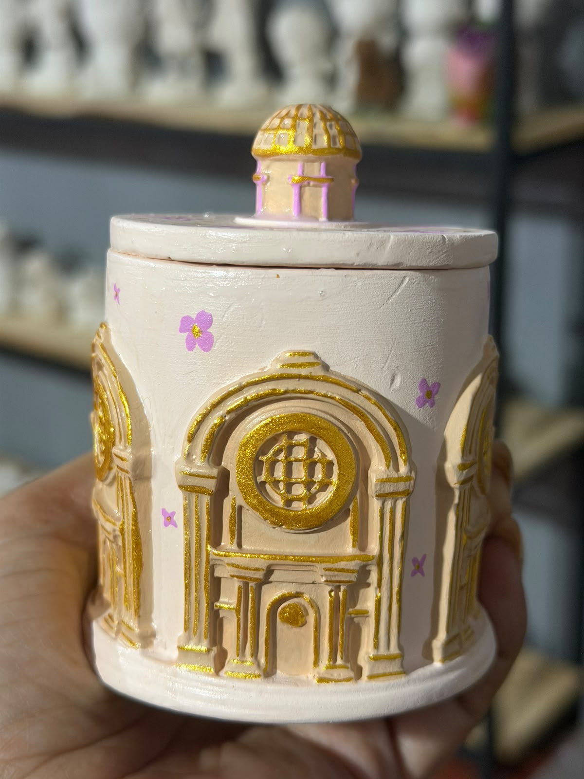 Pieza pintada en blanco y dorado con pequeños detalles de flores rosas